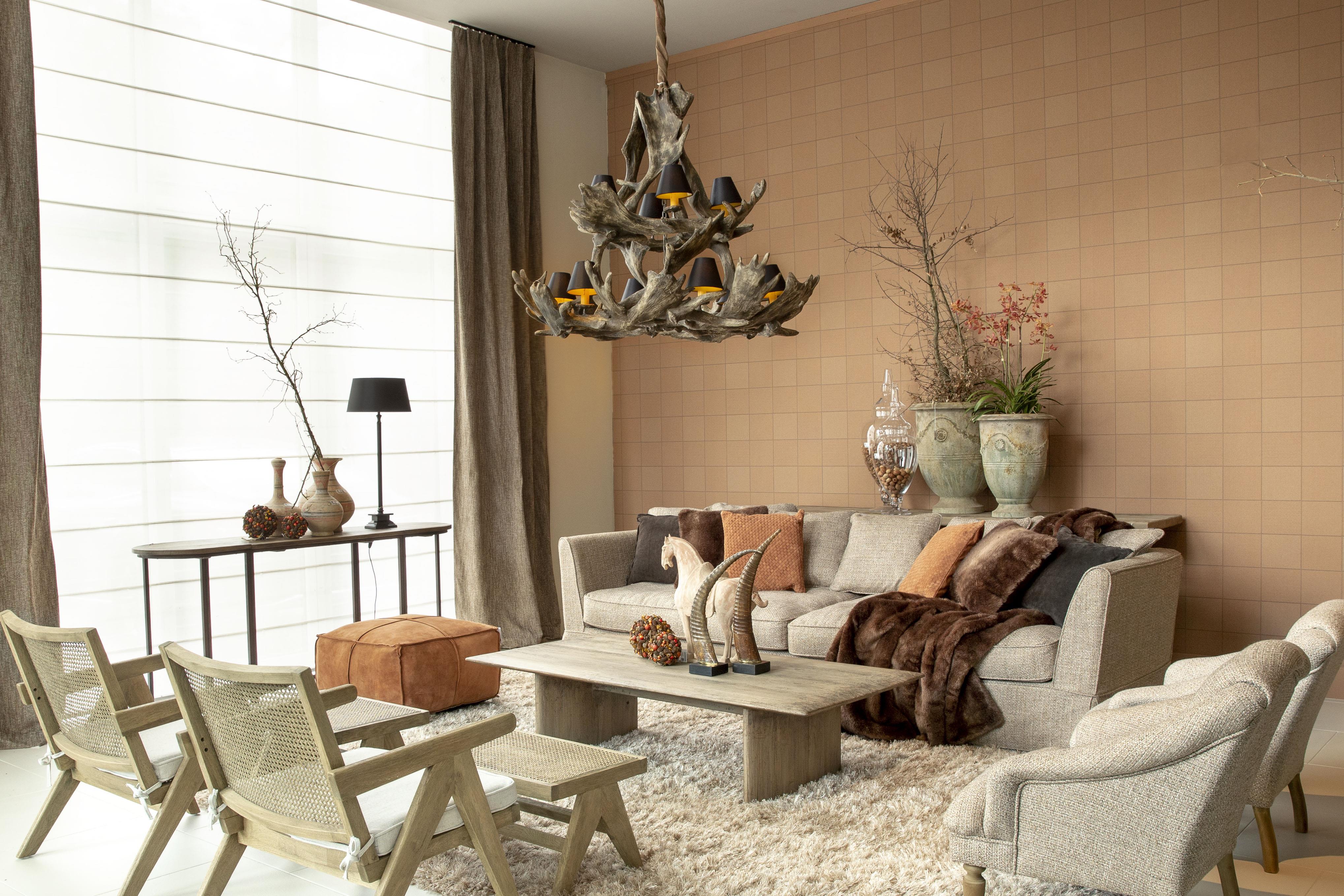 Modern living room with a chandelier, sofa, and chairs.