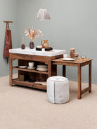 Wooden kitchen island with marble countertop and decorative items against a gray wall.