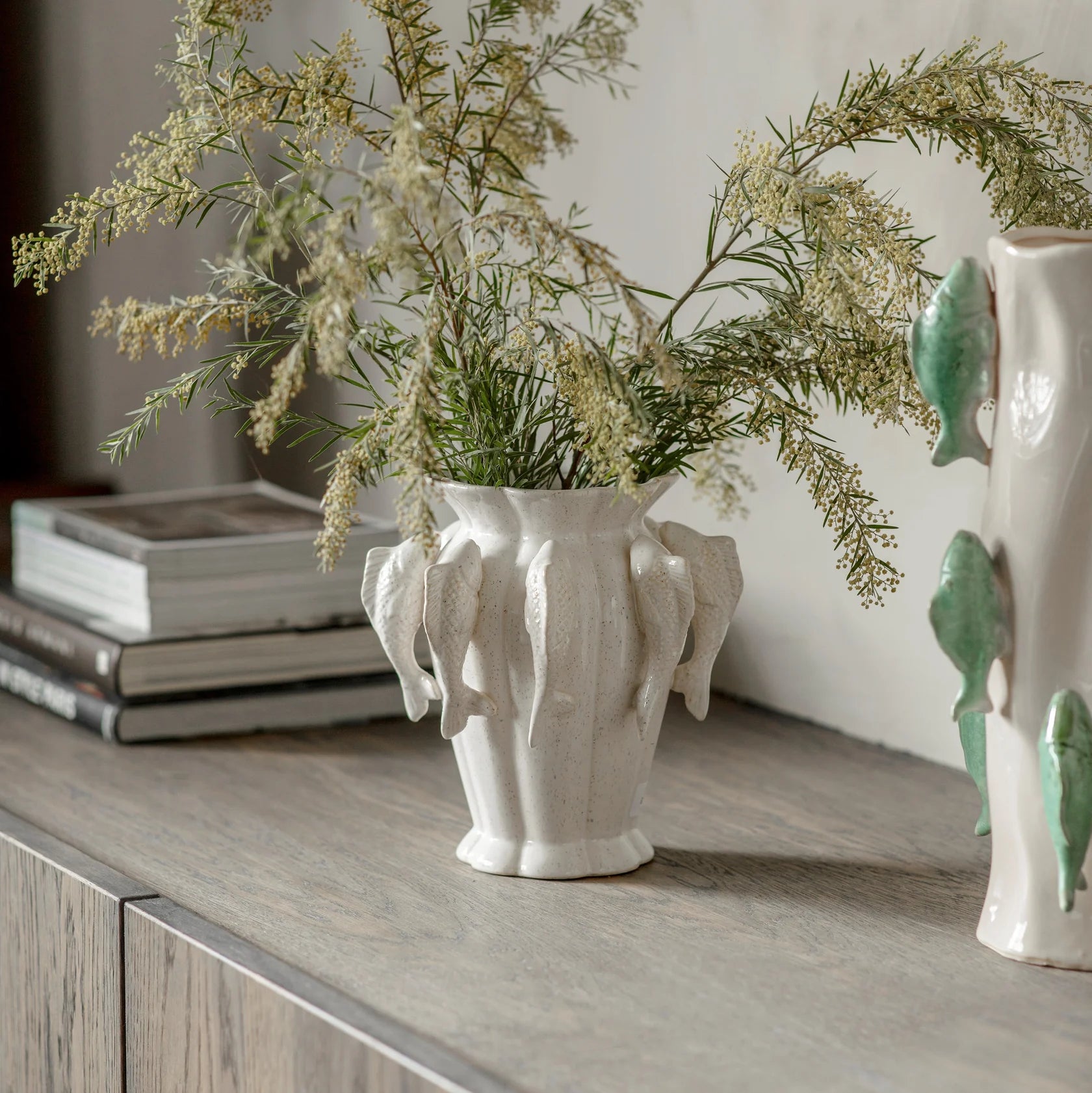 Decorative white vase with floral arrangement on a wooden surface