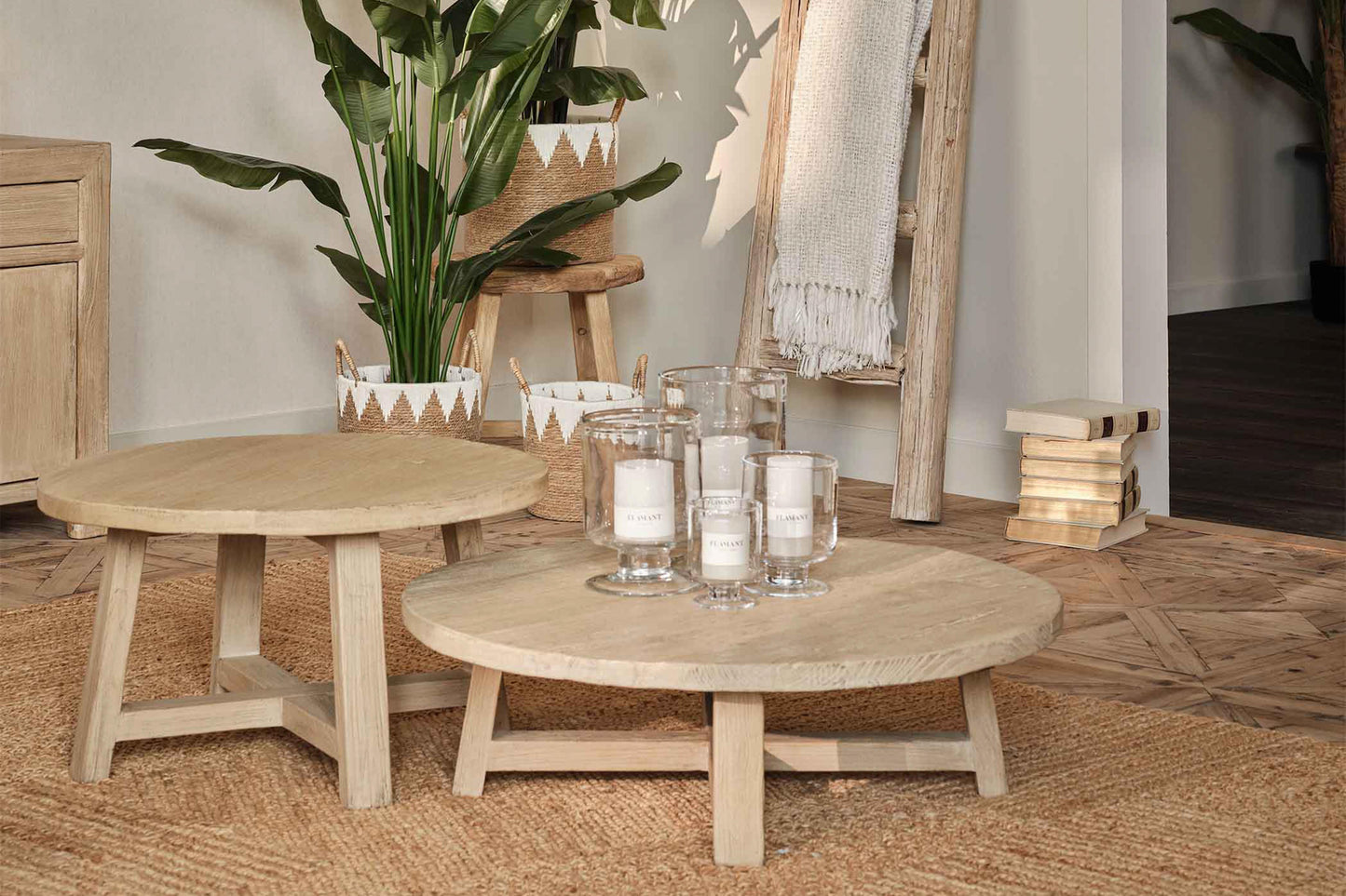 Round wooden coffee table with decorative items in a room setting.