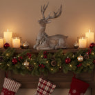 Decorative mantel with a reindeer figurine, candles, and Christmas stockings.