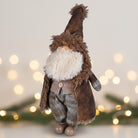 Decorative gnome figure with a brown hat and coat against a blurred light background